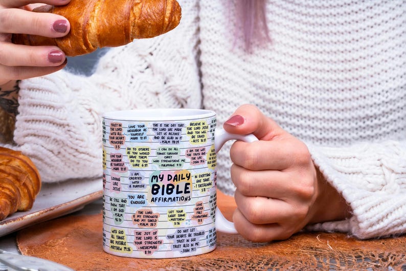 May include: White ceramic mug with a colorful design featuring bible verses and the text "My Daily Bible Affirmations".