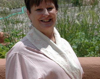 May include: A woman wearing a pink and white striped robe with a white lace collar and cuffs. The robe has a sash tie at the waist.