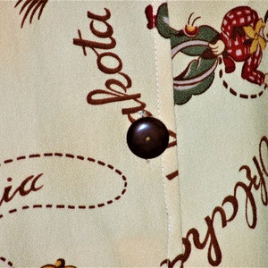 May include: A beige fabric with a brown button and a cartoon cowboy riding a horse. The fabric has the words "California" and "La Jolla" printed on it.