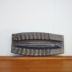 Könnte beinhalten: Eine Keramik-Schale in Fischform mit einer blauen und grauen Glasur. Die Schale hat eine strukturierte Oberfläche und ein erhabenes Design.