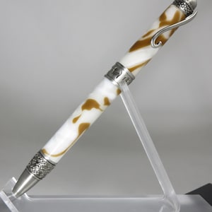 May include: A white and brown swirl pen with a silver metal top and a silver metal cat head design on the top. The pen is on a clear acrylic stand.