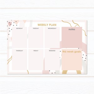 May include: A weekly planner with a pink, white and gold abstract design. The planner has sections for Monday, Tuesday, Wednesday, Thursday, Friday, Weekend, notes, and this week goals.