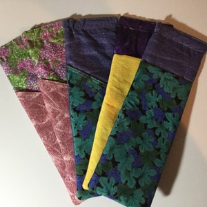 May include: Five fabric pouches with different patterns. The pouches are made of a variety of fabrics, including floral, paisley, and solid colors. The pouches are all the same size and shape.