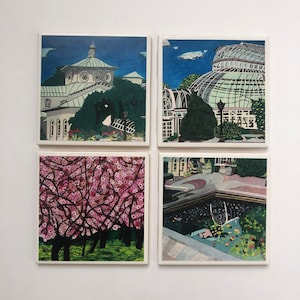 May include: Set of four square ceramic coasters featuring different scenes of a botanical garden. One coaster shows a white building with a green roof, another shows a greenhouse with a glass roof, another shows a pond with lily pads, and the last shows a pink cherry blossom tree.