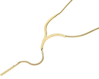 May include: A gold-toned necklace with a unique Y-shaped design. The necklace is made of a thin chain and has a long, thin pendant that hangs down from the Y.