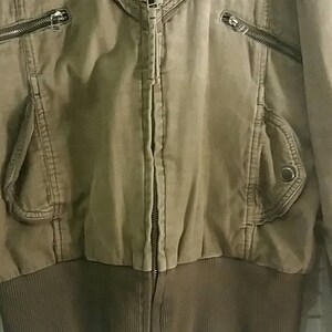 May include: A brown zip-up jacket with a ribbed knit bottom and multiple pockets.