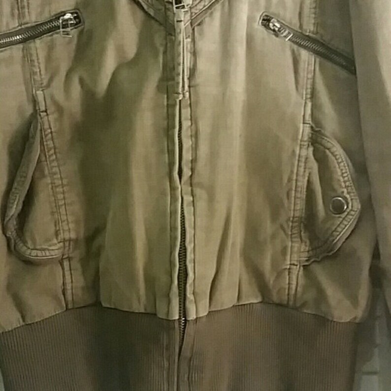 May include: A brown zip-up jacket with a ribbed knit bottom and multiple pockets.