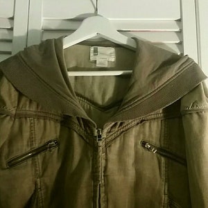 May include: A brown hooded jacket with a zipper closure and multiple pockets. The jacket has a corduroy-like texture and a wide collar.