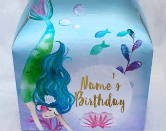 May include: A blue and purple mermaid themed party favor box with a mermaid illustration, bubbles, and fish. The box has a handle and says "Name's Birthday" in gold lettering.