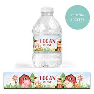 Puede incluir: Una botella de agua de plástico transparente con una etiqueta personalizada con animales de granja y el texto "LOGAN IS ONE". La etiqueta incluye una vaca, un caballo y pollitos. Se muestra una etiqueta a juego debajo de la botella.
