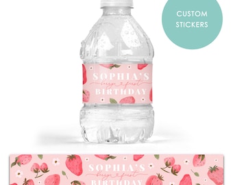 May include: Pink and white water bottle labels with a strawberry design. The labels say "Sophia's First Birthday".