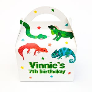 May include: White party favour box with a handle, decorated with colourful illustrations of a green snake, iguana, red lizard, and blue-green chameleon. The text "Vinnie's 7th birthday" is printed on the front, surrounded by star accents.
