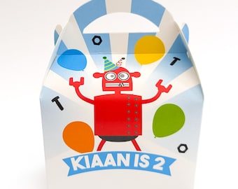May include: A blue and white favor box with a robot design. The robot is red with black eyes and a party hat. The box has the text "KIAAN IS 2" on it.