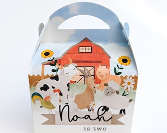 Könnte beinhalten: Ein roter Stall mit einem weißen Fenster, umgeben von Bauernhoftieren wie einer Kuh, einem Schwein, einer Ziege, einem Schaf, einem Hahn und einem Kaninchen. Der Text "Noah is two" ist auf der Vorderseite der Schachtel aufgedruckt.