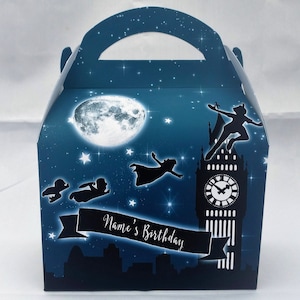 May include: A blue and white Peter Pan themed party favour box with a silhouette of Big Ben, stars, and Peter Pan flying. The box has a handle and says "Name's Birthday" on a banner.