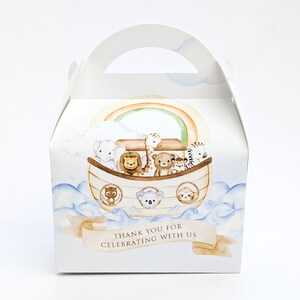 May include: White gable box with a handle, featuring a watercolour illustration of Noah's Ark with animals, a rainbow, and the text "THANK YOU FOR CELEBRATING WITH US". The box has a light blue and tan colour scheme.