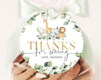 Peut inclure: Une étiquette ronde blanche avec une bordure de couronne d'eucalyptus verte. Au centre, une illustration aquarelle d'une girafe, d'un zèbre, d'un lion et d'un éléphant. Le texte dit "THANKS for coming LOVE, HUDSON".