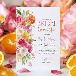 Puede incluir: Una invitación a un brunch nupcial con detalles florales y cítricos. La invitación presenta el texto "BRIDAL brunch" y los detalles del evento de Camila Davis el 25 de agosto. Naranjas en rodajas y flores rosas rodean la invitación.