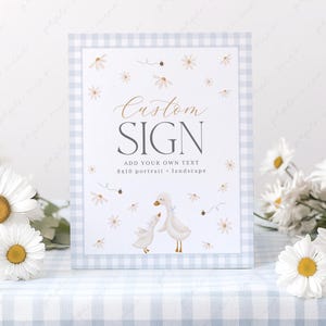 Könnte beinhalten: Ein blaues und weißes Gingham-Schild mit dem Text "Custom Sign" und "Add your own text 8x10 portrait or landscape". Das Schild zeigt eine Aquarell-Illustration von zwei weißen Gänsen mit braunen Schnäbeln und Füßen, umgeben von rosa Blumen und Bienen.