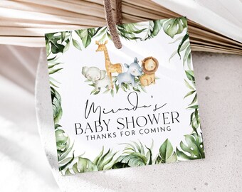 May include: A white square tag with a green foliage border. The tag says "Miranda's Baby Shower Thanks for Coming" in black text. There are illustrations of a giraffe, elephant, lion, and zebra in the centre of the tag.