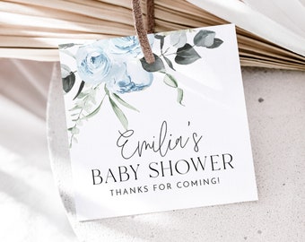 Op de afbeelding: Een wit bedankkaartje met blauwe aquarelbloemen en groene bladeren. De tekst luidt "Emilia's Baby Shower Bedankt voor je komst!"