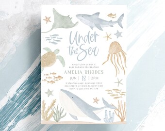 Könnte beinhalten: Eine Babyparty-Einladung mit einem Unterwasser-Thema. Die Einladung zeigt eine Aquarell-Illustration eines Wals, eines Hais, eines Rochen, einer Schildkröte, einer Qualle und Seesternen. Der Text auf der Einladung lautet "Under the Sea" und enthält den Namen Amelia Rhodes, das Datum 18. Juni, die Uhrzeit 14:00 Uhr, den Ort 5 Starfish Lane, Sunshine Cove, und die RSVP-Informationen.