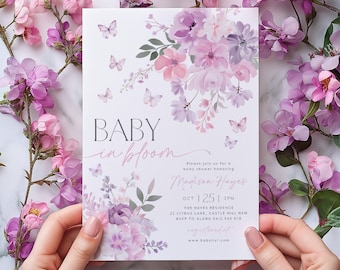 Puede incluir: Una invitación a una fiesta de bienvenida al bebé con un diseño floral en tonos morados y rosas. El texto dice "BABY in bloom" e incluye el nombre "Madison Hayes", la fecha "OCT 25", la hora "2PM", la ubicación "THE HAYES RESIDENCE" y la dirección "22 CITRUS LANE, CASTLE HILL NSW".