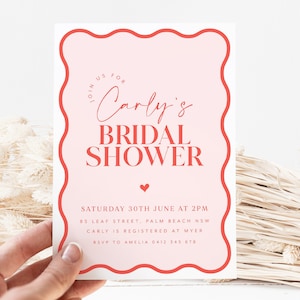 May include: Pink bridal shower invitation with a wavy border in red. The text reads "Join us for Carly's Bridal Shower" with a small heart at the bottom. The invitation includes the date, time, address, and RSVP information.