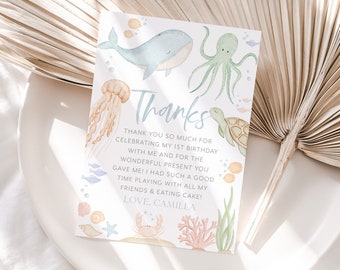 May include: A watercolor thank you card with an ocean theme. The card features a whale, octopus, jellyfish, turtle, and crab. The text on the card reads "Thanks" and "Thank you so much for celebrating my 1st birthday with me and for the wonderful present you gave me! I had such a good time playing with all my friends & eating cake! Love, Camilla."