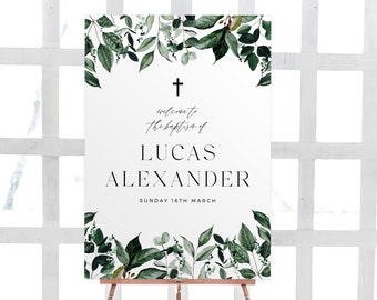 May include: A white sign with green watercolor leaves and a cross at the top. The text reads "Welcome to the baptism of Lucas Alexander Sunday 16th March".