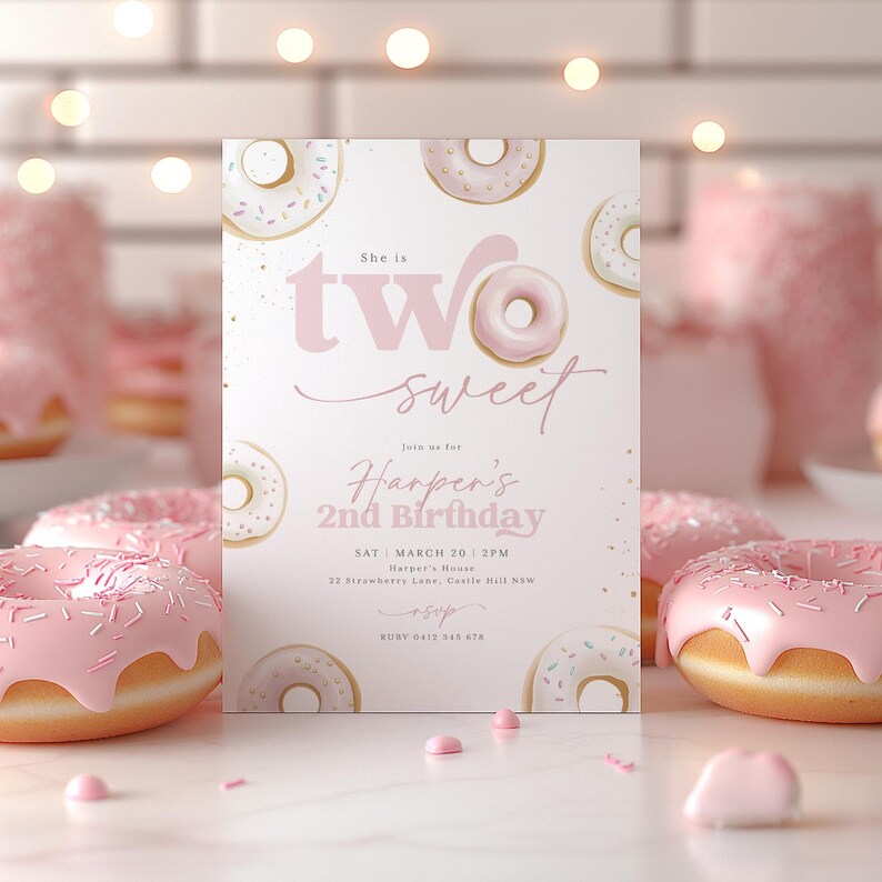 May include: A pink and white birthday invitation with a donut theme. The invitation says "She is two sweet" and includes the text "Join us for Harper's 2nd Birthday" with the date and time of the party. The invitation is decorated with pink and white donuts.