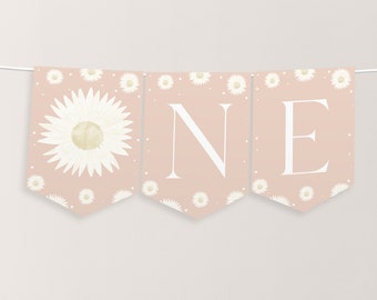 Op de afbeelding: Een roze en witte banner met het woord "ONE" in witte letters. De banner is versierd met witte madeliefjes en witte stippen.