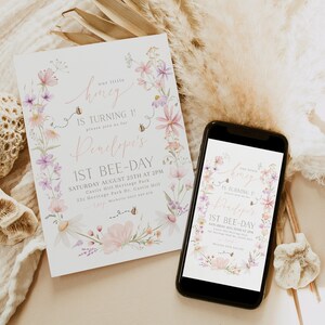 K&ouml;nnte beinhalten: Eine Einladung im floralen Design f&uuml;r eine erste Geburtstagsfeier. Die Einladung zeigt einen Kranz aus rosa und lila Blumen mit Bienen und dem Text "our little honey is turning 1! please join us for Penelope's 1st bee-day" sowie die Partydetails.