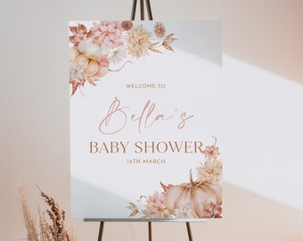 May include: Welcome to Bella's Baby Shower on 16th March. A white sign with brown text and floral illustrations of pumpkins and flowers.
