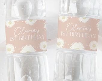 May include: Two clear plastic water bottles with pink and white daisy patterned labels. The labels say "Olivia's 1st Birthday".