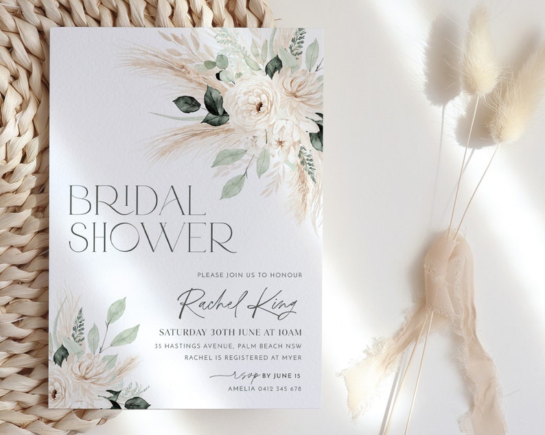 Op de afbeelding: Een witte kaart met een aquarel bloemenontwerp en de tekst "BRIDAL SHOWER" in zwart. De kaart bevat ook de tekst "PLEASE JOIN US TO HONOUR Rachel King SATURDAY 30TH JUNE AT 10AM 35 HASTINGS AVENUE, PALM BEACH NSW RACHEL IS REGISTERED AT MYER RSVP BY JUNE 15 AMELIA 0412 345 678"