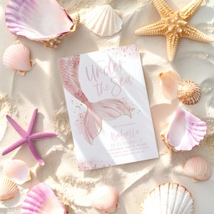K&ouml;nnte beinhalten: Eine Illustration einer rosafarbenen und goldenen Meerjungfrauenflosse mit dem Text "Under the Sea" und "Our Little Mermaid Isabella is turning 3!" auf wei&szlig;em Hintergrund. Die Einladung enth&auml;lt Datum, Uhrzeit und Ort der Party.