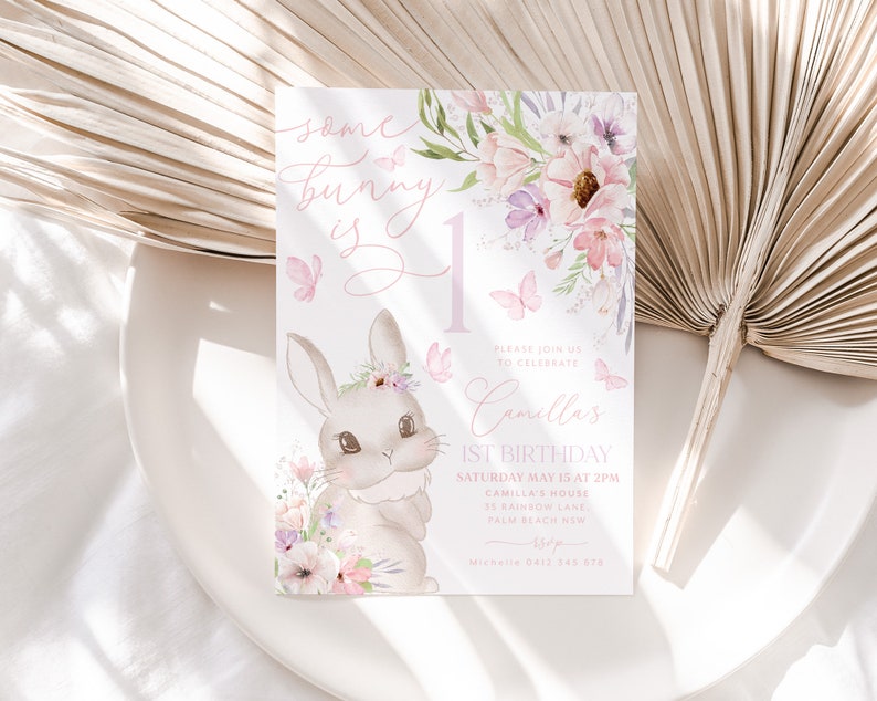 May include: A pastel-colored birthday invitation featuring a bunny illustration and floral accents. The text reads "Some bunny is 1" and includes details for Camilla's 1st birthday celebration, including the date, time, and location.