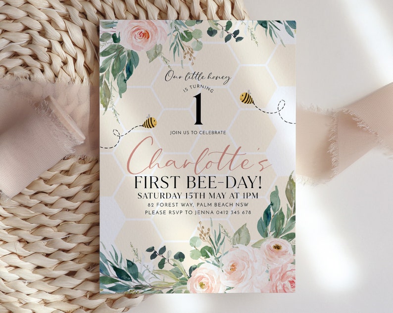 May include: A birthday invitation featuring the text "Our little honey is turning 1" and "Charlotte's FIRST BEE-DAY!". The design incorporates watercolor roses, greenery, and a honeycomb pattern with a bee illustration. The invitation is for a first birthday celebration.