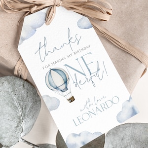 May include: Blue and white watercolor thank you tag with a hot air balloon illustration. The tag says "Thanks for making my birthday one derful!" with love Leonardo.