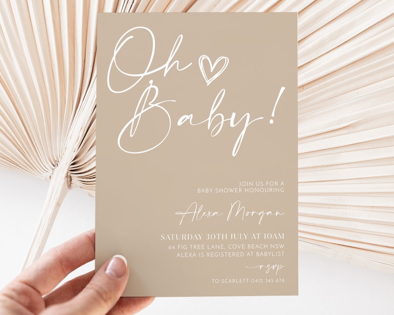 May include: A beige baby shower invitation with white script that reads "Oh Baby!" with a heart. The invitation includes the details of the event, including the date, time, location, and RSVP information.