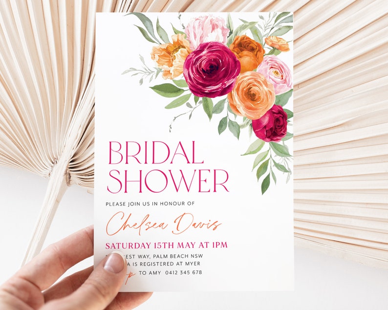 May include: A white bridal shower invitation with a floral design in shades of pink, orange, and red. The text reads "Bridal Shower" in a pink font and "Please join us in honor of Chelsea Davis" in a brown font. The date and time of the shower are listed as "Saturday 15th May at 1pm".