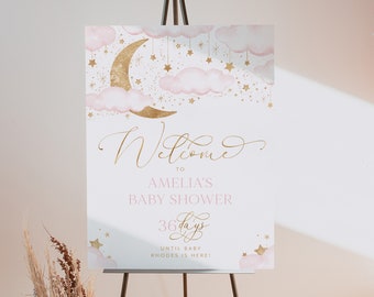 Può includere: Un cartello di benvenuto per la baby shower di Amelia con un design a luna e stelle rosa e oro. Il cartello dice "Benvenuti alla baby shower di Amelia 36 giorni fino all'arrivo del piccolo Rhodes!"