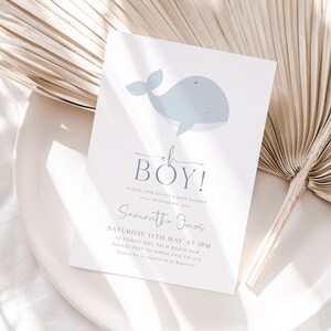 Op de afbeelding: Een uitnodiging voor een babyshower met een lichtblauwe walvisillustratie. De tekst luidt "Oh Boy!" en bevat details over het evenement, zoals datum, tijd en locatie. De uitnodiging staat op een witte achtergrond.