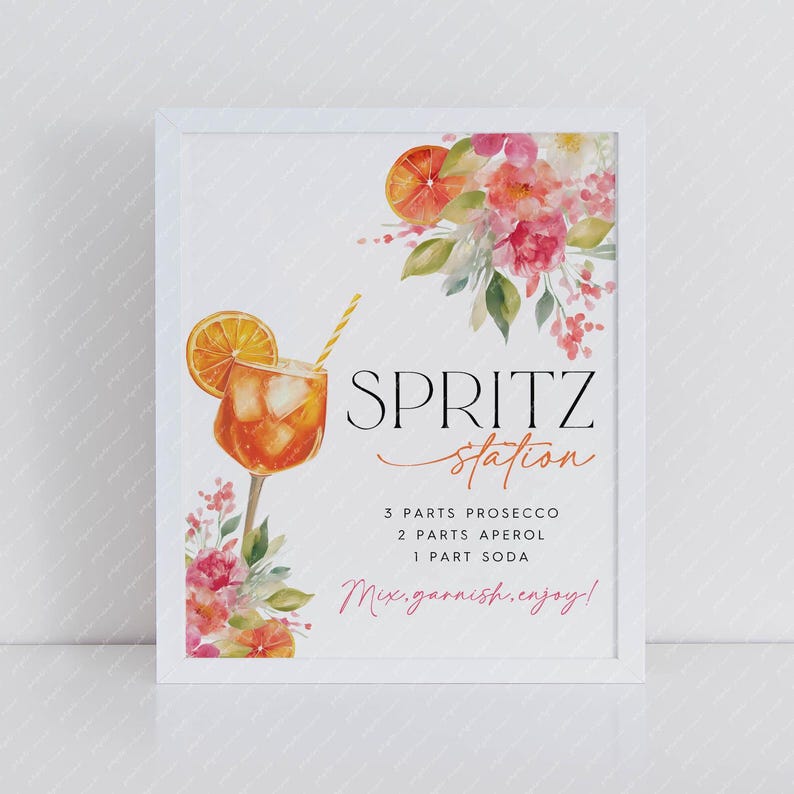 May include: A framed print with a watercolor illustration of a spritz cocktail and floral accents. The text reads "Spritz Station" with a recipe: 3 parts Prosecco, 2 parts Aperol, 1 part soda. Includes the text "Mix, garnish, enjoy!"