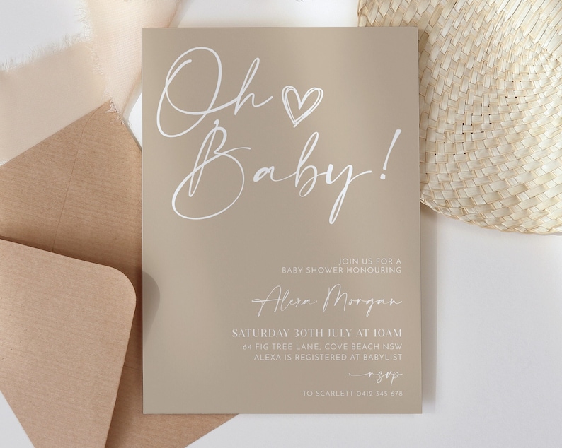May include: Beige baby shower invitation with white calligraphy that reads "Oh Baby!" and includes the details of the event: "Join us for a baby shower honouring Alexa Morgan, Saturday 30th July at 10am, 64 Fig Tree Lane, Cove Beach NSW, Alexa is registered at Babylist, To Scarlett 0412 345 678."