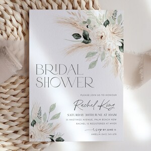 Op de afbeelding: Een witte kaart met een bloemenmotief en de tekst "BRIDAL SHOWER" in zwart. De kaart bevat ook de tekst "PLEASE JOIN US TO HONOUR Rachel King SATURDAY 30TH JUNE AT 10AM 35 HASTINGS AVENUE, PALM BEACH NSW RACHEL IS REGISTERED AT MYER RSVP BY JUNE 15 AMELIA 0412 345 678"