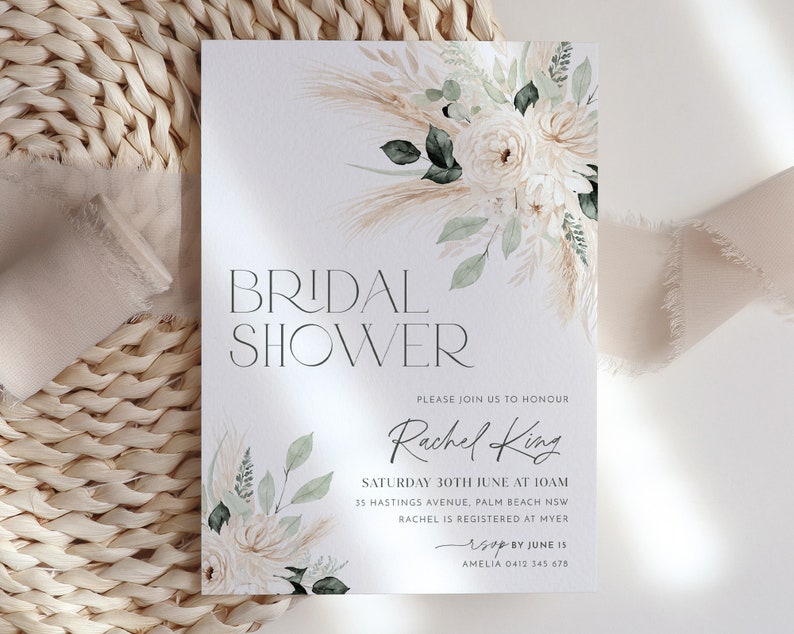 Op de afbeelding: Een witte kaart met een bloemenmotief en de tekst "BRIDAL SHOWER" in zwart. De kaart bevat ook de tekst "PLEASE JOIN US TO HONOUR Rachel King SATURDAY 30TH JUNE AT 10AM 35 HASTINGS AVENUE, PALM BEACH NSW RACHEL IS REGISTERED AT MYER RSVP BY JUNE 15 AMELIA 0412 345 678"