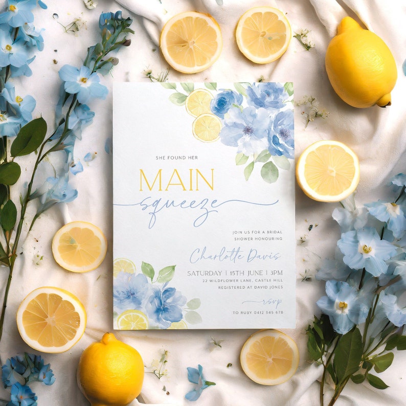Puede incluir: Una invitaci&oacute;n de ducha nupcial azul y amarilla con flores y limones en acuarela. La invitaci&oacute;n dice "She found her main squeeze" e incluye el nombre de la novia, la fecha, la hora y la ubicaci&oacute;n. Tambi&eacute;n se incluye informaci&oacute;n de RSVP.
