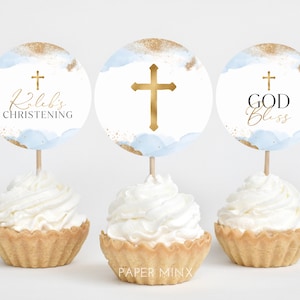 May include: Three cupcake toppers with blue and gold watercolor designs. The toppers feature a cross, the text "Kaleb's Christening", and the text "God Bless".